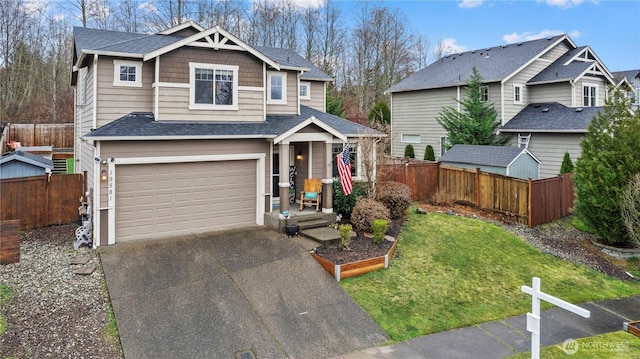 view of front of property featuring roof with shingles, an attached garage, a front yard, fence, and driveway