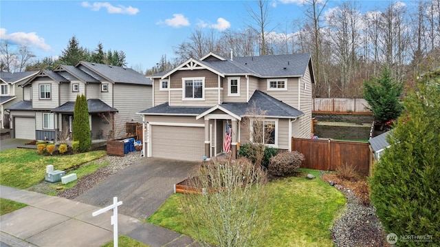 view of front of property with driveway, a residential view, roof with shingles, fence, and a front lawn