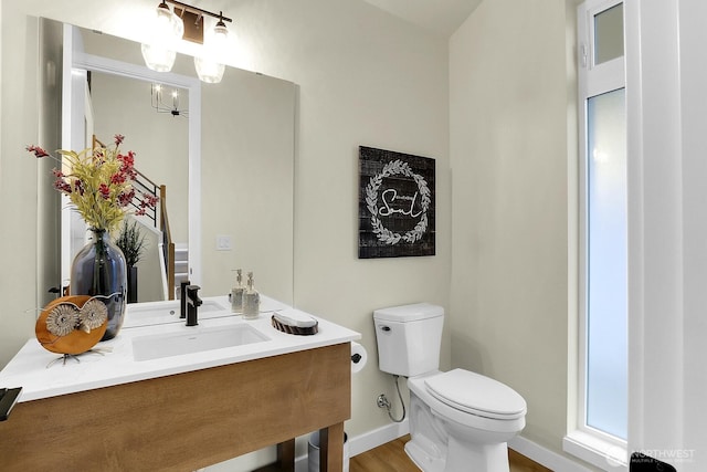 bathroom featuring vanity, toilet, and baseboards