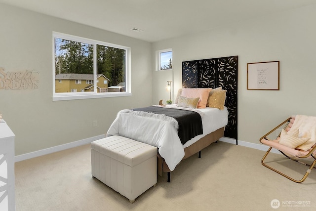 bedroom with baseboards, visible vents, and light colored carpet