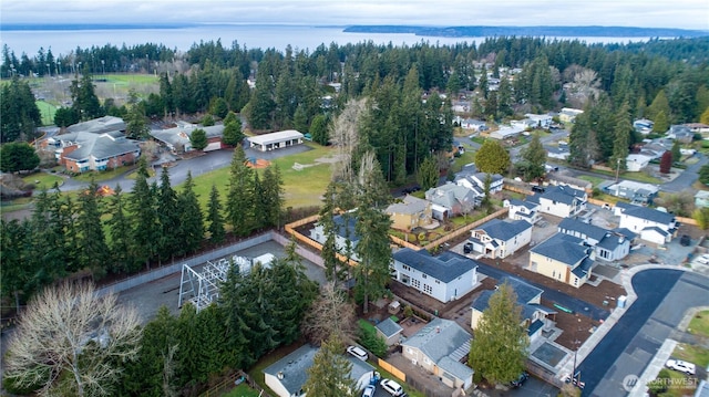 birds eye view of property featuring a residential view, a water view, and a forest view