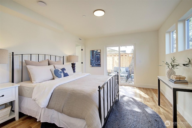 bedroom with access to outside, multiple windows, and light wood-type flooring