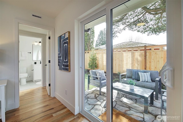 entryway with baseboards, visible vents, and light wood-style floors