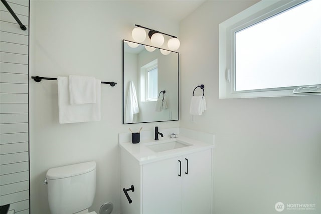 bathroom featuring vanity, toilet, and a healthy amount of sunlight