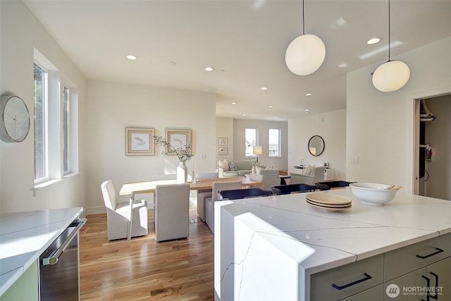 kitchen featuring light wood-style floors, recessed lighting, pendant lighting, and light stone countertops