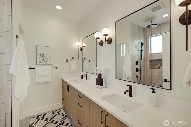 bathroom featuring visible vents, a sink, baseboards, and double vanity