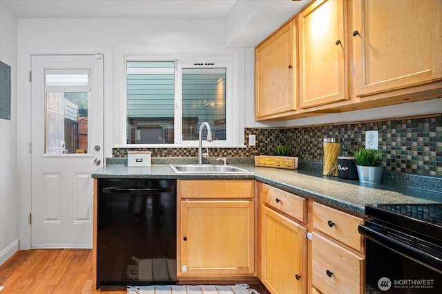 kitchen featuring light wood-style flooring, a sink, black dishwasher, decorative backsplash, and dark countertops