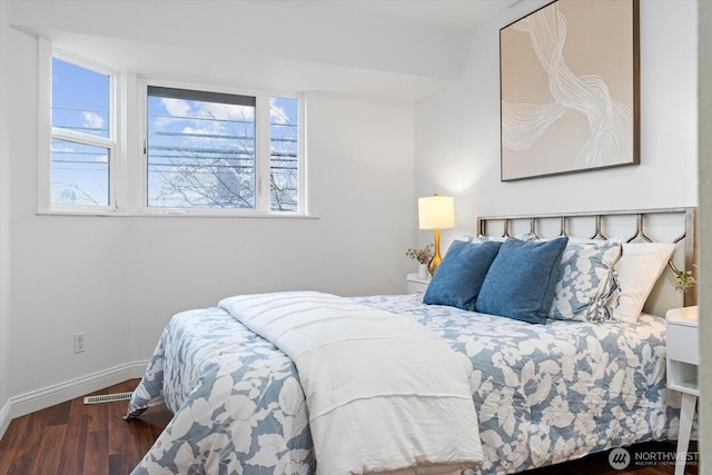 bedroom featuring visible vents, baseboards, and dark wood-type flooring