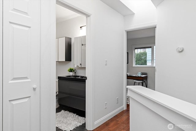 interior space featuring wood finished floors, vanity, and baseboards