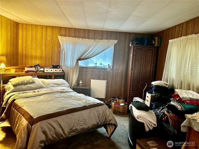 bedroom with carpet floors and wooden walls