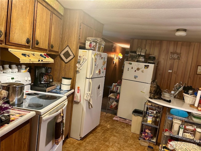 kitchen with light countertops, white appliances, brown cabinetry, and under cabinet range hood