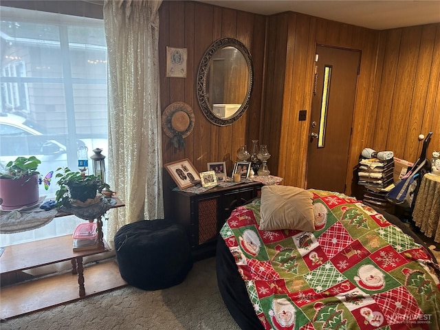 carpeted bedroom featuring wooden walls