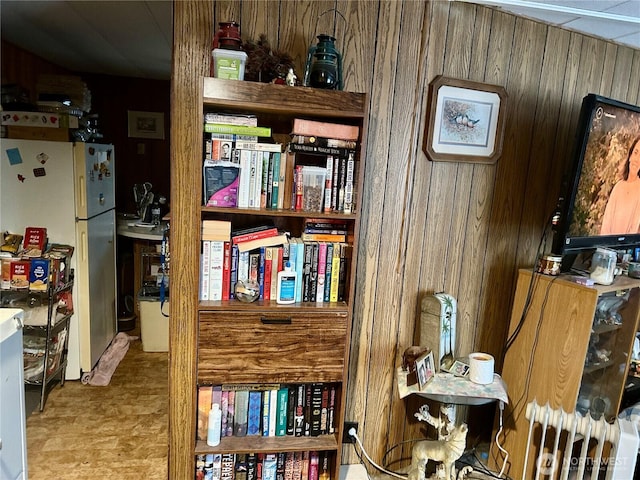 details featuring freestanding refrigerator and wooden walls