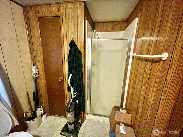 bathroom with a shower stall and wooden walls