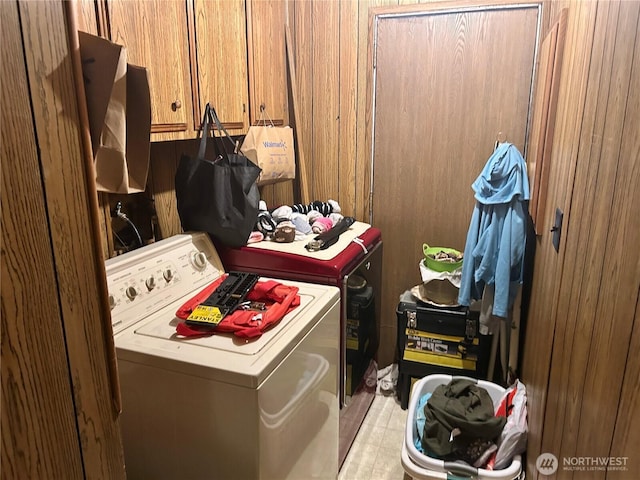 laundry room with cabinet space, washing machine and dryer, and wooden walls