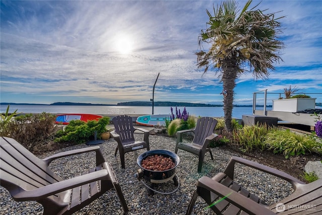 view of patio / terrace with an outdoor fire pit and a water view