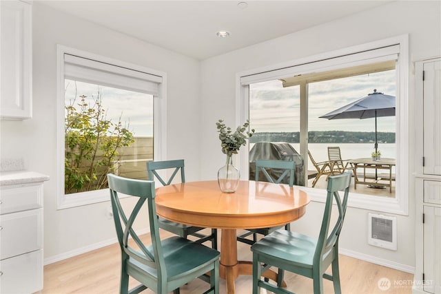 dining area featuring a healthy amount of sunlight, light wood-type flooring, and baseboards