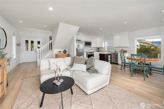 living area featuring stairs, recessed lighting, and light wood-style floors