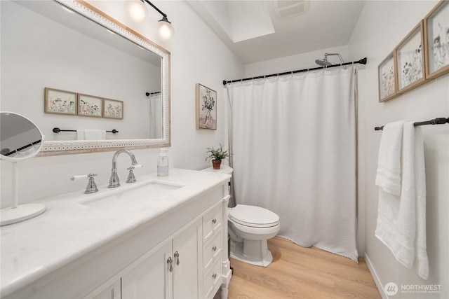 bathroom featuring visible vents, curtained shower, toilet, wood finished floors, and vanity