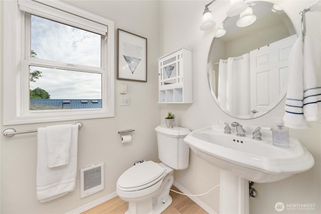 full bathroom with toilet, wood finished floors, baseboards, and a sink