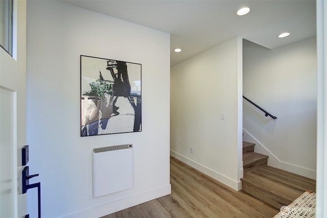 hallway with recessed lighting, baseboards, light wood finished floors, and stairs