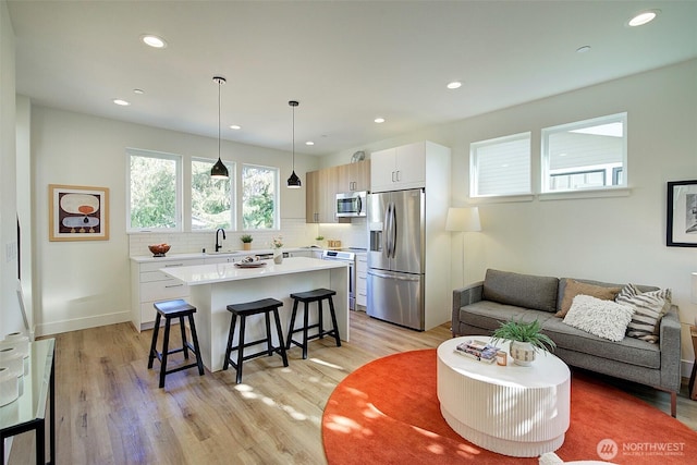 living area with light wood-style floors, recessed lighting, and baseboards