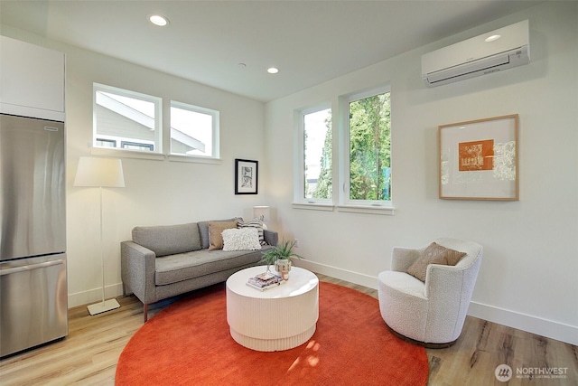 living area featuring baseboards, recessed lighting, a wall mounted air conditioner, and light wood-style floors