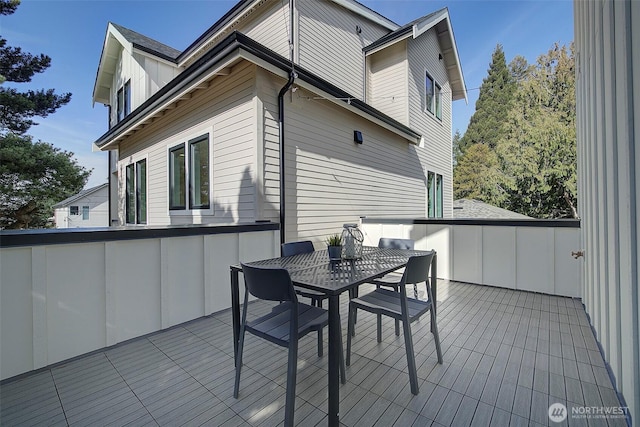 exterior space with a wooden deck, board and batten siding, and outdoor dining space