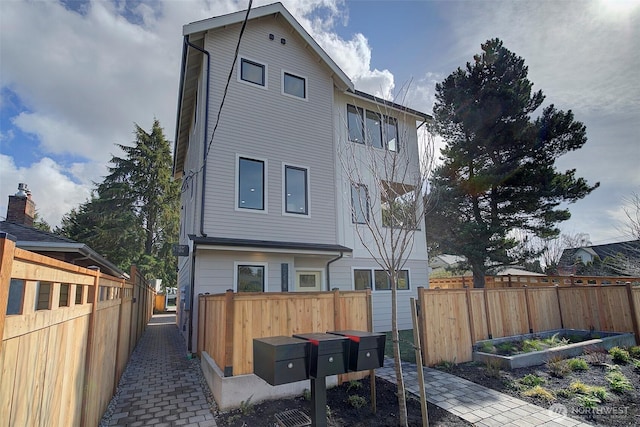 rear view of house with fence and a garden