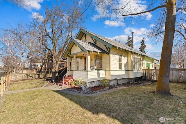 view of front of home featuring a front yard, covered porch, and a fenced backyard