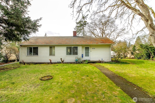 view of front facade with a chimney and a front yard