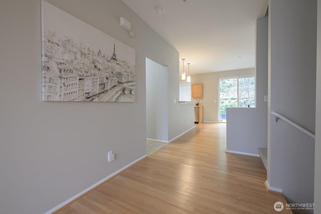 hallway with light wood-type flooring and baseboards