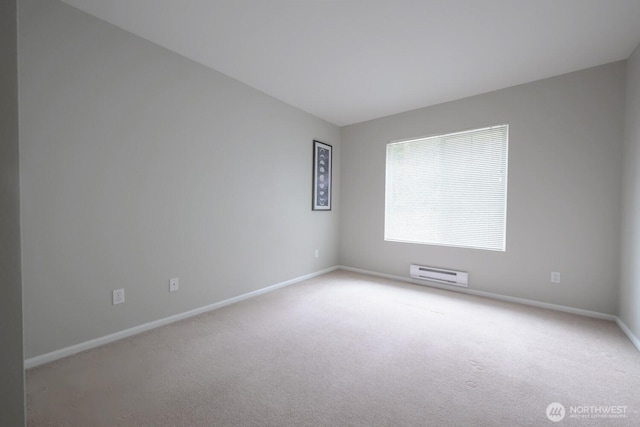 spare room featuring light carpet and baseboards