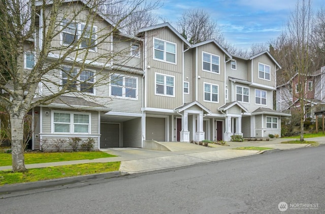 townhome / multi-family property featuring a garage, concrete driveway, and a carport