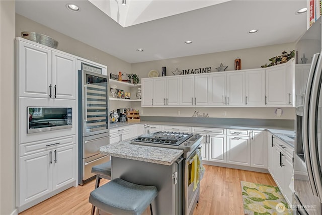 kitchen featuring stainless steel appliances, light wood-type flooring, and white cabinets