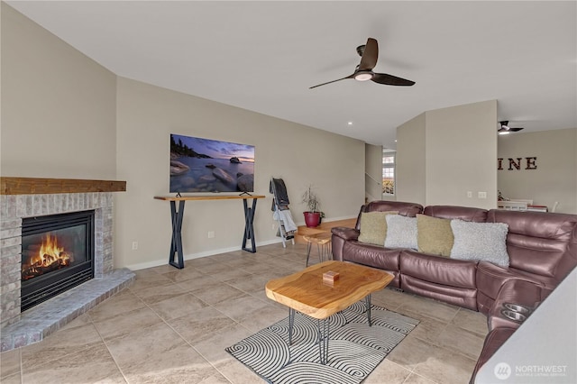 living room featuring a brick fireplace, baseboards, and a ceiling fan