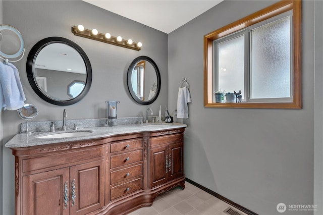 bathroom featuring double vanity, visible vents, baseboards, and a sink