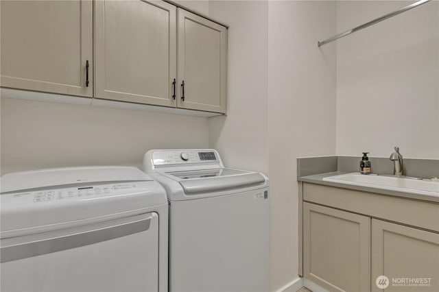 washroom with cabinet space, a sink, and washing machine and clothes dryer