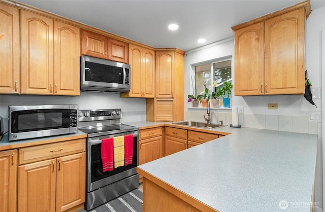 kitchen with stainless steel appliances, recessed lighting, light countertops, and a sink