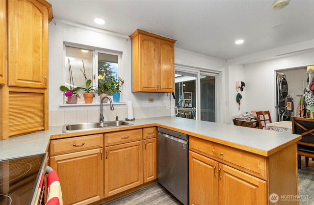 kitchen with recessed lighting, stainless steel appliances, a peninsula, a sink, and light countertops