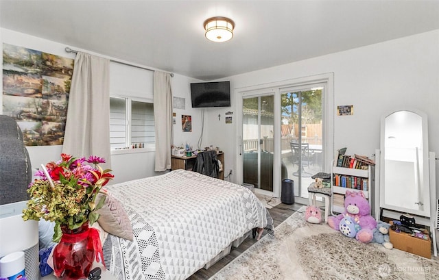 bedroom with access to exterior, arched walkways, and wood finished floors