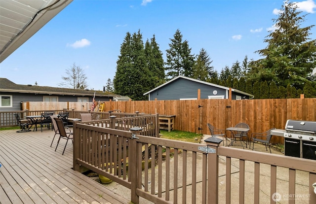 deck with a fenced backyard, area for grilling, and outdoor dining space