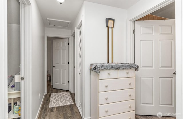 hall with attic access, baseboards, and dark wood finished floors