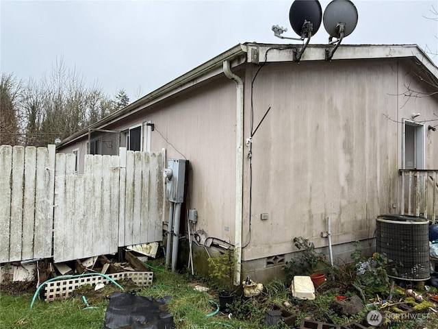 view of side of property featuring crawl space, fence, and central air condition unit