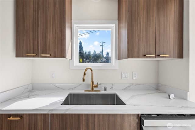 kitchen with brown cabinetry, a sink, dishwashing machine, and modern cabinets