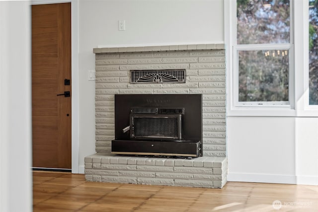 details with visible vents, a fireplace, and wood finished floors