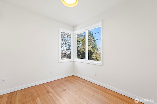 spare room featuring baseboards and hardwood / wood-style floors