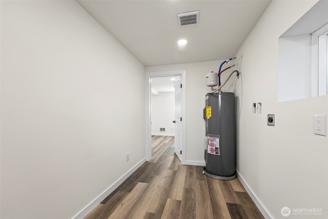 utility room with visible vents and electric water heater