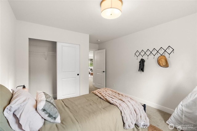 bedroom with a closet, carpet flooring, and baseboards