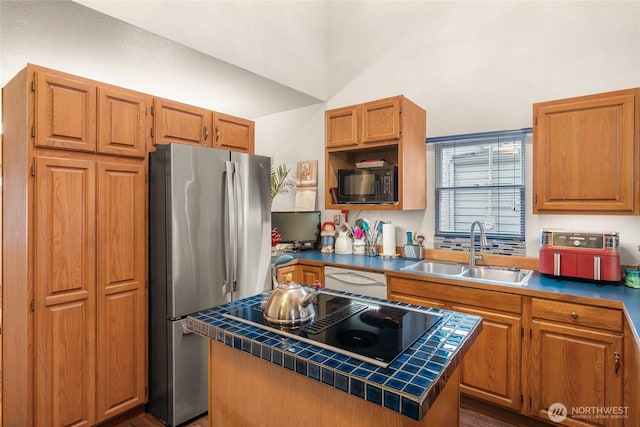 kitchen featuring a kitchen island, a sink, tile counters, black appliances, and brown cabinetry